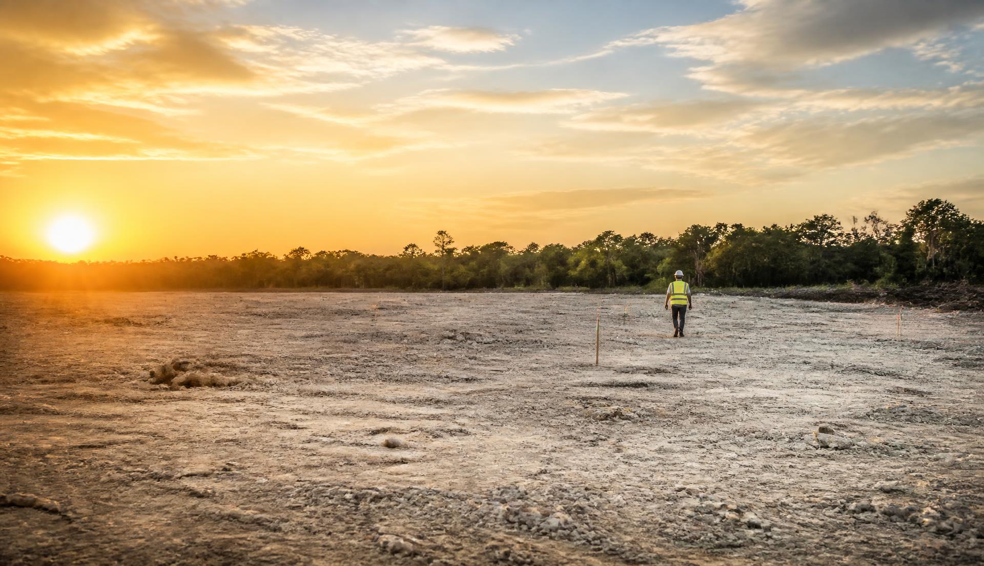 Terreno despejado con estacas de trazo al atardecer en Quintana Roo